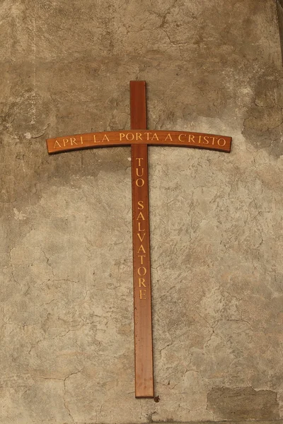 Croix sur un vieux mur de stuc avec inscription sur italien — Photo