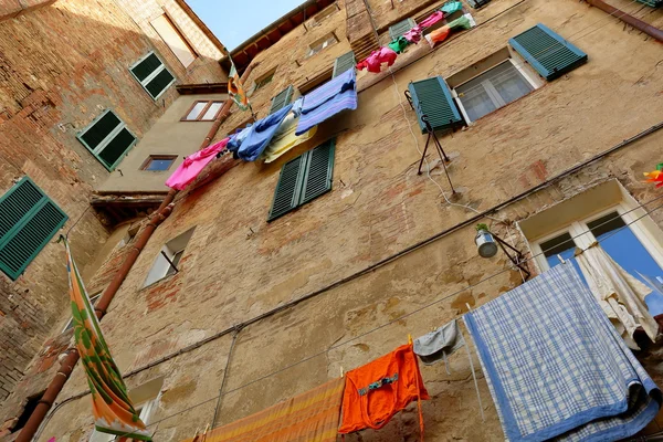 Ancient building with windows and the drying linen — Stock Photo, Image