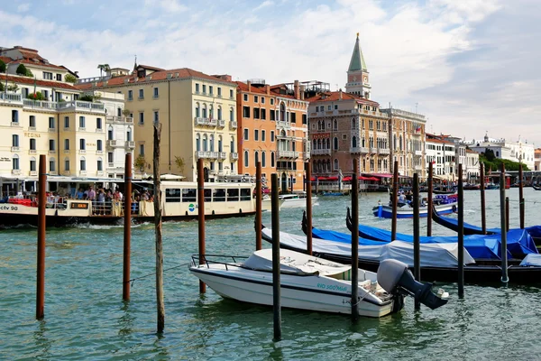 Venecia, Italia. Lancha motora estacionada y góndolas cerca de postes de madera — Foto de Stock