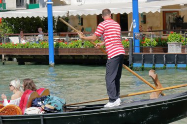 Gondolcu yolcularla gondolda kürek kürek. Venedik, İtalya
