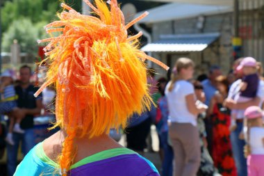 Palyaço kırmızı peruk ile insanlar kalabalığa benziyor