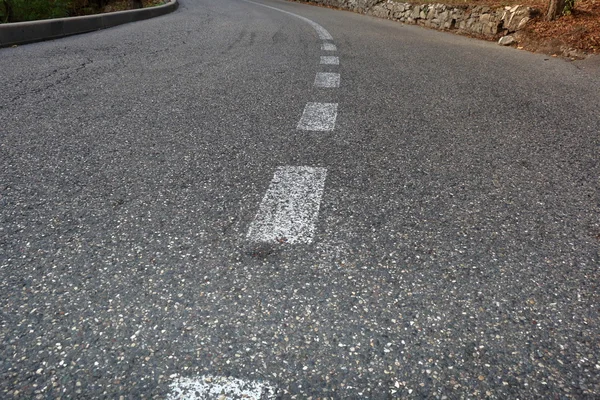 Estrada pavimentada com linha divisória. Foco em primeiro plano — Fotografia de Stock