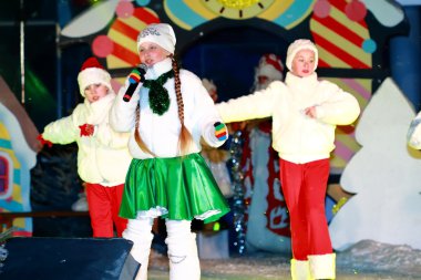 Kız mikrofon ile sahne alanı'nda bir şarkı söyler