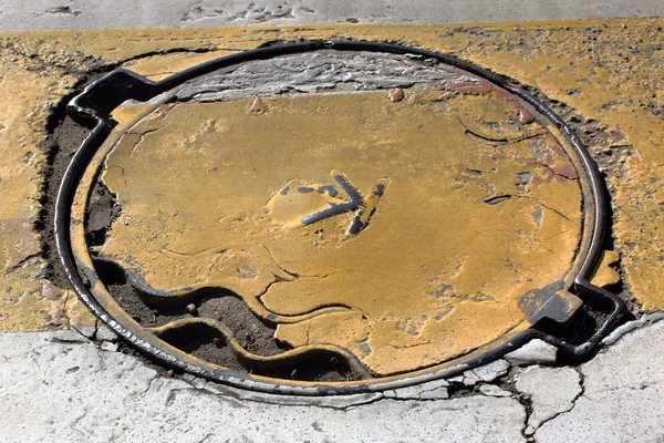 Old manhole with yellow paint