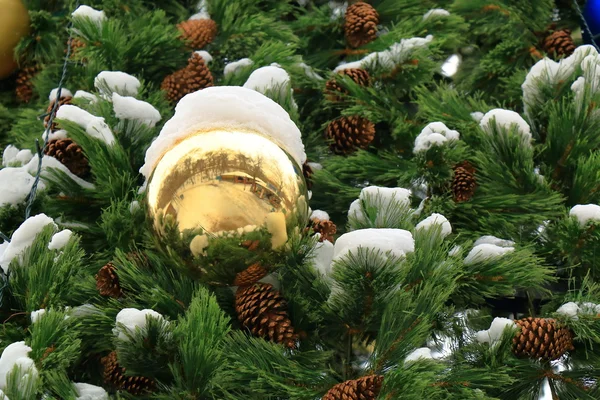 Grote gele bal met sneeuw op de kerstboom — Stockfoto