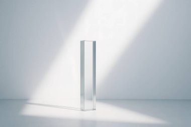 Temiz, minimal bir odada güçlü çapraz güneş ışığıyla aydınlatılan uzun, şeffaf bir cam sütun, gevrek gölgeler ve parlak, yüksek anahtarlı ticari bir atmosfer yaratıyor..