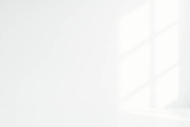 Yumuşak doğal güneş ışığıyla donuk pencere gölgeleri oluşturan minimum beyaz iç duvar, cömert kopya alanı ile temiz bir nötr arkaplan oluşturur..