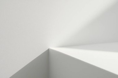 Yumuşak doğal güneş ışığı pencerenin içinde geometrik gölgeler oluşturarak en az beyaz iç duvar ve zemin üzerinde temiz kopya alanı ile.