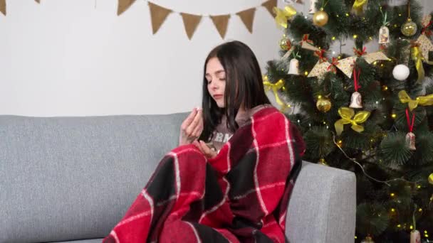 クリスマス休暇中の病気の女性は風邪薬を飲みながら家にいます — ストック動画