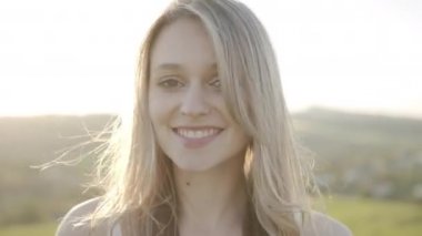 Güneşin altında bir kadının neşeli ve nazik bakışları.