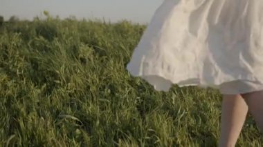 Kahverengi ayakkabılı kızın bacakları çimenlere değiyor.