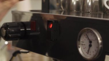 Kahve makinesiyle barista ustaları düğmeye basıyor.