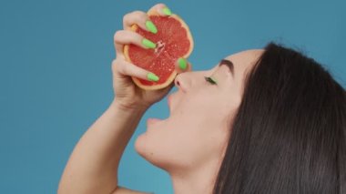 Elinde greyfurtla seksi bir kızın çerçevesini kapat.