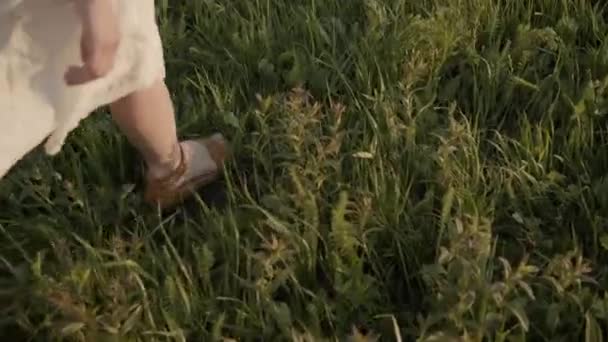 Игривая девушка кружит ногами на ковре из травы — стоковое видео