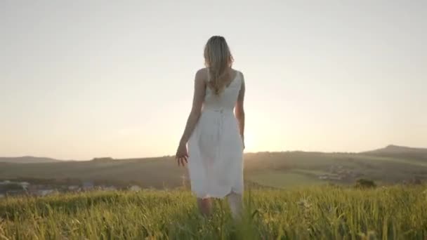 Девушка в белом платье играет руками и солнечным светом — стоковое видео