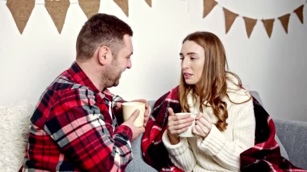 Mężczyzna w czerwonej koszuli i kobieta w białym swetrze rozmawiająca ze sobą o filiżance kakao — Wideo stockowe