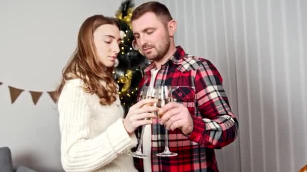 Мужчина и женщина держат бокал шампанского и обнимаются друг с другом — стоковое видео