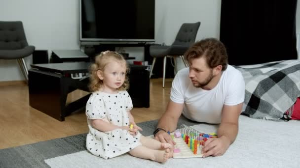 Padre joven enseña hija pequeña para distinguir diferentes formas geométricas — Vídeos de Stock