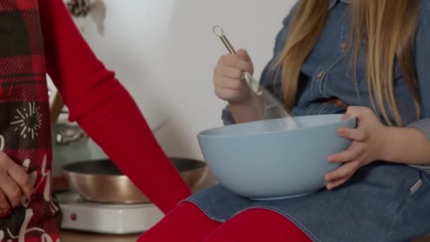 Liten flicka hjälper sin mamma i matlagning middag — Stockvideo