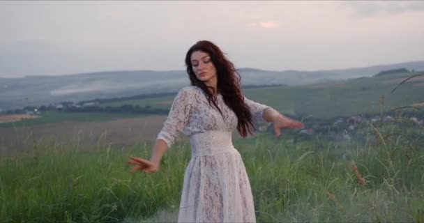 Mulher sedutora está dançando no prado em um prado verde — Vídeo de Stock