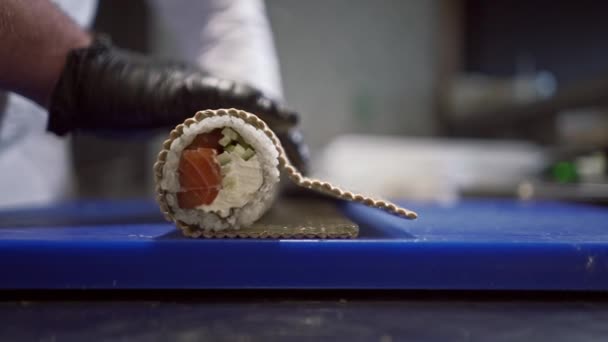 Detailní záběr na odvážné mužské ruce pečlivě rozkládající hotové sushi před podáváním — Stock video