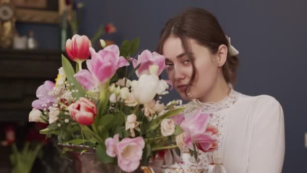 Zbliżenie ramki pięknej dziewczyny z niebieskimi oczami z bukietem pięknych pachnących kwiatów — Wideo stockowe
