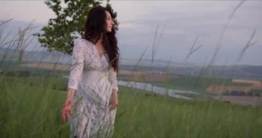 Ellerinde çiçeklerle tarladaki kız doğanın tadını çıkarıyor.
