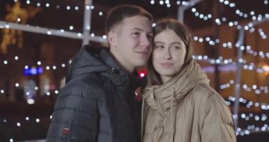 Fotoğraf çekmek için kameraya poz veren genç ve güzel bir çifti yakından çek.