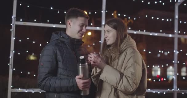 Genç kız akşam yürüyüşü sırasında sevgilisine sıcak çay ikram eder. — Stok video