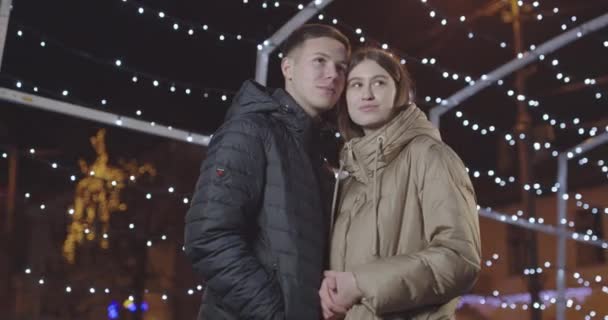 Молодая пара наслаждаются друг другом во время прогулки зимним вечером — стоковое видео