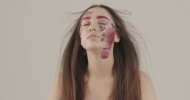 Kırılgan omuzları olan güzel bir kız havanın saçlarıyla oynamasından hoşlanıyor.