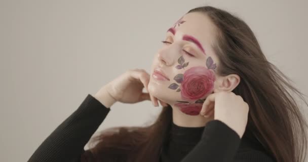 Fată tânără atinge elegant fața ei cu mâinile ei în timp ce pozează pentru camera din studio — Videoclip de stoc