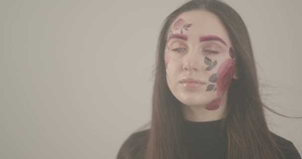 Hermosa chica con la cara brillantemente pintada es emocionado por el rodaje en el estudio — Vídeos de Stock