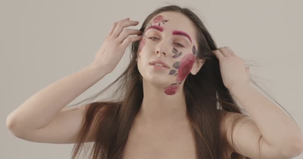 Dívka s křehkými holými rameny a krásné dlouhé vlasy elegantně pózuje pro fotoaparát dotýká její tvář — Stock video