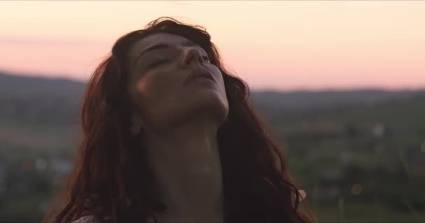 Young woman enjoys the moment on the background of the evening sky — Stock Video