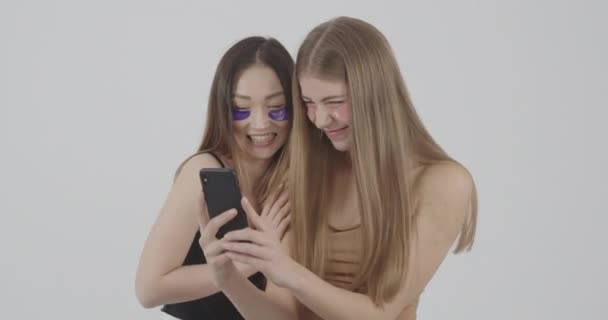 Meninas navegar nas fotos do estúdio tomadas em um smartphone e escolher o melhor — Vídeo de Stock