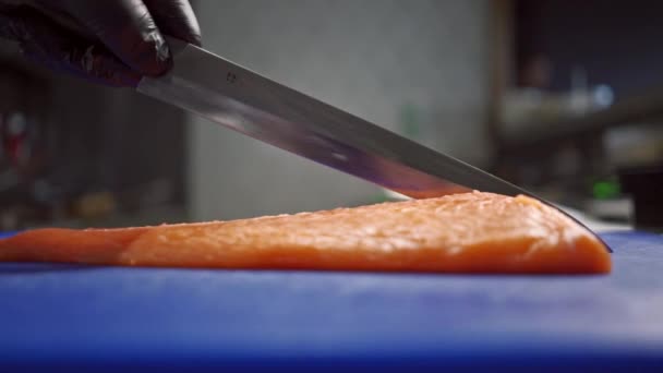 Großer Rahmen von Herrenhänden, die leicht duftenden und frischen roten Fisch schneiden, um köstliches Sushi zu machen — Stockvideo