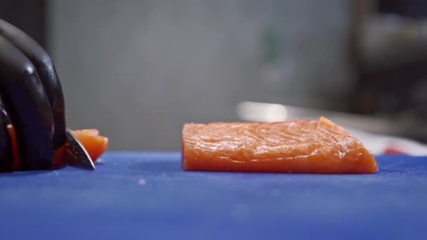 Suşi şefi gelecekteki suşi için ön form yapmak için kırmızı balıkları dikkatlice parçalara ayırıyor. — Stok video