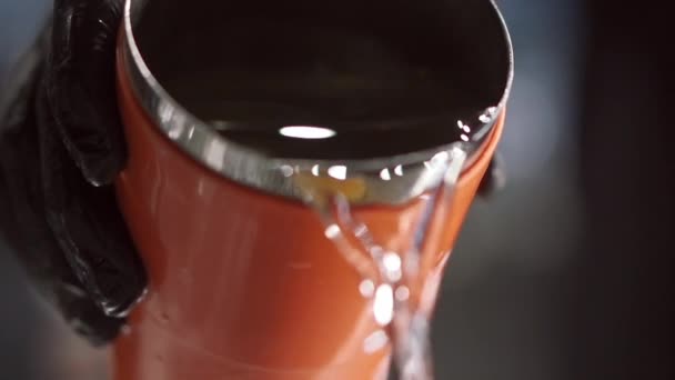 Zbliżenie odważnych męskich rąk ostrożnie wylewających świeżą wodę z czerwonego karafki — Wideo stockowe