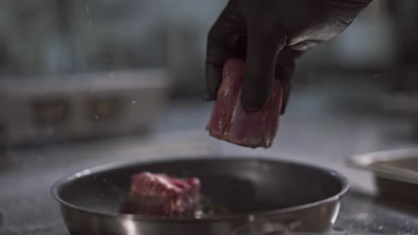 Primer plano de las manos del chef que arroja cuidadosamente la carne apetitosa para asar — Vídeos de Stock