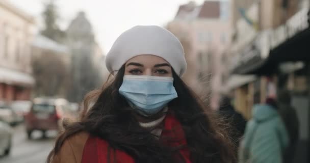 Fată tânără cu păr lung și întunecat superb într-o mască în centrul orașului, care simbolizează umanitatea într-o pandemie covidă — Videoclip de stoc