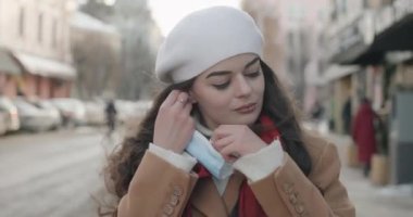 Genç ve güzel bir kız maskesini çıkarıp koronavirüsü durdurmayı ve karantinayı sonlandırmayı savunuyor. Kapsamlı Durdur