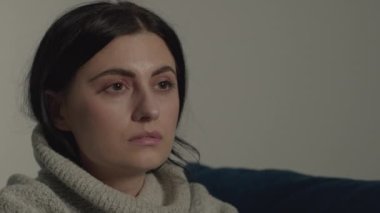 Kafası karışık bir bakışla sadece bir noktaya bakan, sürekli farklı düşüncelere süzülen üzgün bir kadının yakın çekimi.