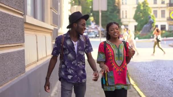 Étudiants étrangers marchant autour de la ville par une chaude journée d'été — Video