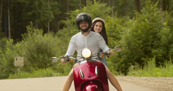 Primo piano di una giovane coppia con sorrisi felici sul viso mentre guida uno scooter — Video Stock