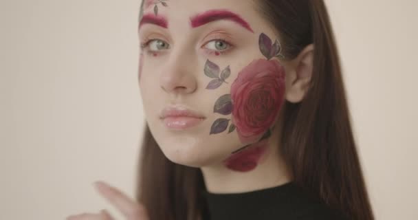 Portrét mladé krásné dívky s dlouhými tmavými vlasy s elegantní tělo umění na její tváři — Stock video