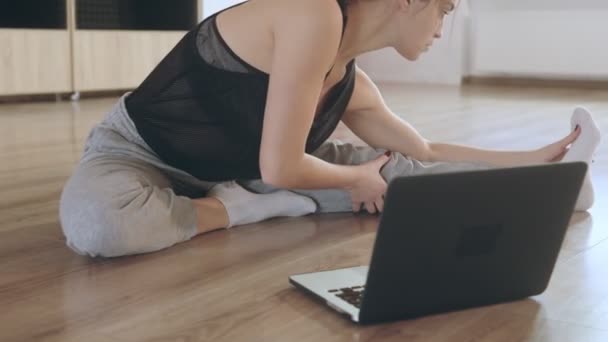 La chica está aprendiendo un nuevo hobby por su cuenta. Ella está comprometida con un entrenador en línea en el gimnasio. — Vídeos de Stock