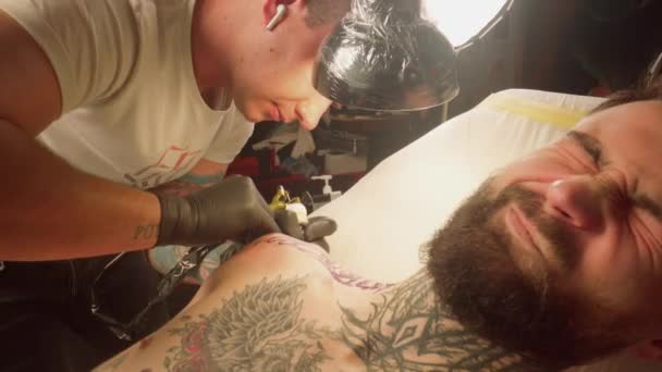 Реальні емоції клієнта в процесі набивання татуювання — стокове відео