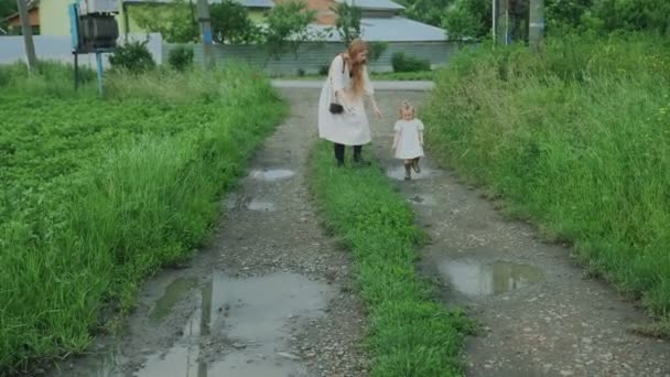 Mamma går med barnet i byn. Går bland fälten. — Stockvideo