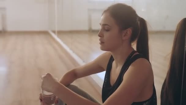 Herstel na de training. Het meisje drinkt water.. — Stockvideo